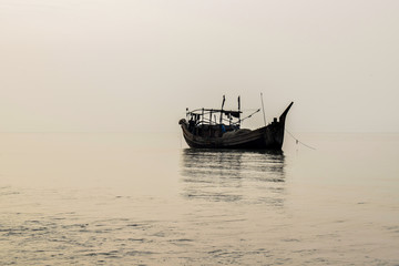 Fototapeta premium Single boat parked in the bank of an ocean in the sea beach with no people near it