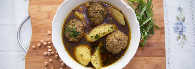 Traditional Azerbaijani Kufta bozbash - pea soup with lamb meatballs, made of minced meat and rice, zesty dried plum inside and boiled potatoes topped with dried mint and sumac . Kufta bozbash soup .