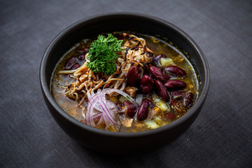 Bean soup with smoked pork, potatoes, herbs, onion