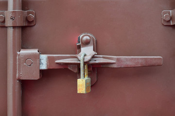 Steel door bolt lock on an old container on a brown floor