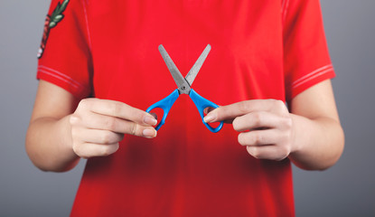 woman hand holding blue scissors