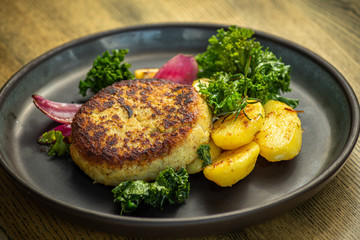 Cooked cod fish cutlet with potatoes, lettuce