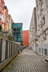 narrow street in santander with blue elevator