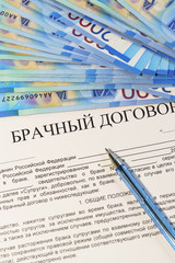 Registration of a marriage contract. Marriage of convenience. New blue ruble banknotes, pen and Russian text