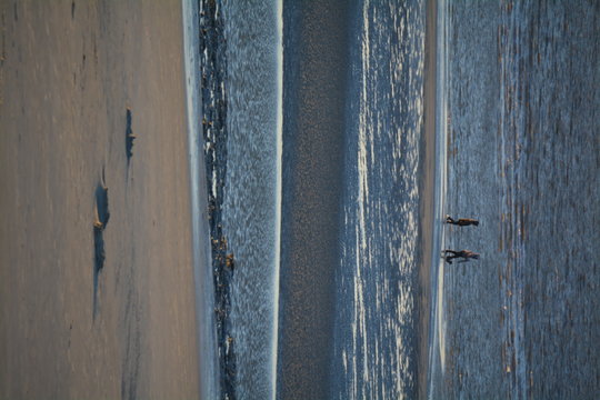 Mid Distance View Of People Walking At Beach