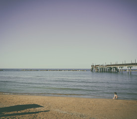 Fototapeta na wymiar Sunset on the beach, child playing by the sea