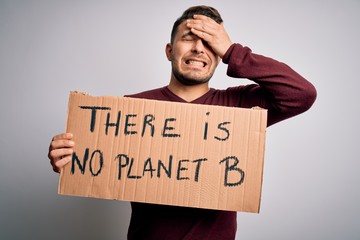 Young activist man holding protest banner for climate change and environment change stressed with...
