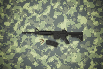 American caliber 5.56 mm rifle on camouflage background