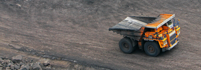 A heavy truck in a quarry carries coal