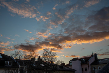Naklejka na ściany i meble Silhouette of house rood and trees with cloudy sky on sunset