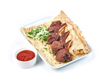 Lamb skewers on the bone with sauce in a restaurant close-up