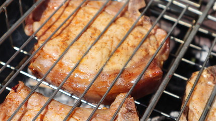 Pork steaks cooked on a charcoal grill outdoors