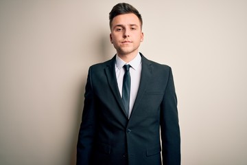 Young handsome business man wearing elegant suit and tie over isolated background Relaxed with serious expression on face. Simple and natural looking at the camera.