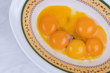 Raw eggs yolks in the bowl on the table