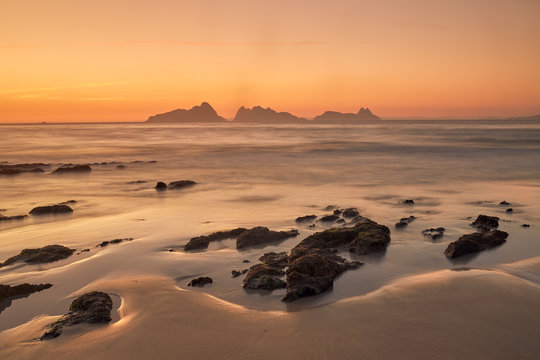 Sunset on the beach of Patos with the silhouette of the Cies islands in the background.