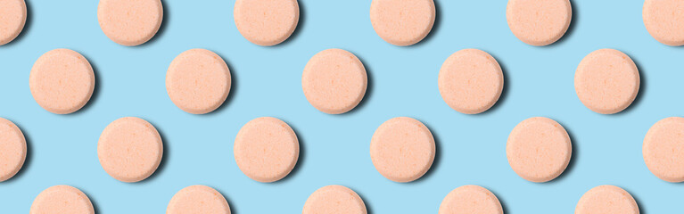 Seamless pattern of pharmaceutical pills or vitamins on a blue background. Orange pills on a blue background.