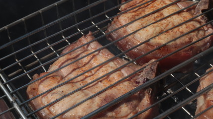Pork steaks cooked on a charcoal grill outdoors