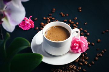 white espresso Cup and pink flowers on the table