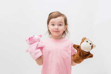 A little girl with toys on her hands on a white background with an open seat. Cute Girl playing...