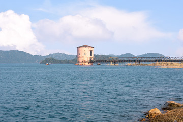 Fototapeta na wymiar a pump house in the middle of the maithon lake with beautiful clouds