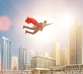 Obraz na płótnie Canvas Superhero businessman flying over the city