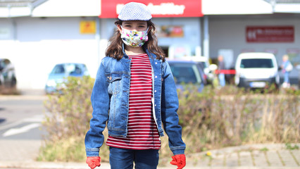 Ein Mädchen geht mit ihrem Bruder mit Mundschutz einkaufen