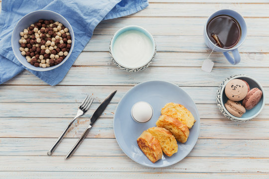 Breakfast with fried croutons, yogurt and black tea on light wooden background. Summer country food.
