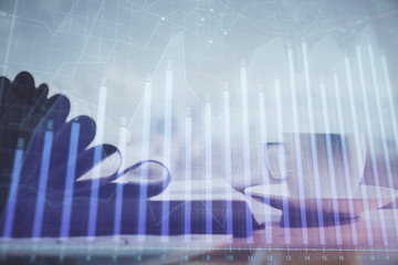 Naklejka premium Double exposure of financial chart drawing and desktop with coffee and items on table background. Concept of forex market trading