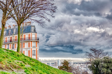 Nice urban landscape that combines nature with a city building. It is a classic residential building and in the background the horizon. It is in HDR mode and the clouds are emphasized