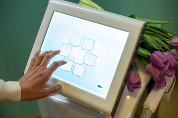 Hand choosing menu on displays of medical laser hair removal device