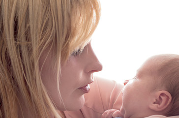 Loving mom holds her newborn baby in her arms, cute tiny baby. Portrait a Mom and her baby. The...