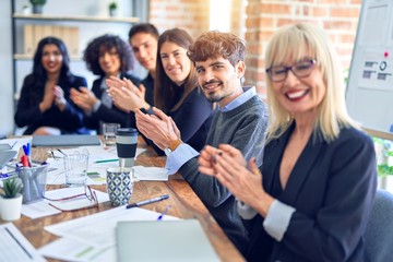 Group of business workers smiling happy and confident. Working together with smile on face looking at the camera applauding at the office