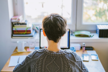Woman working on desk in home office. Young caucasian short hair woman working online from home on...