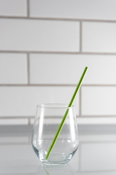 Transparent Empty Glass With Green Paper Drinking Straw In The Kitchen