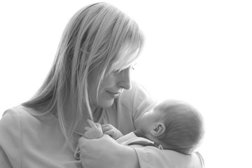 Loving mom holds her newborn baby in her arms, cute tiny baby. Black-and-white portrait mom and her baby. The concept of a happy family. Beautiful conceptual image of motherhood. Mothers Day.
