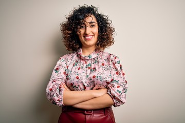 Young beautiful curly arab woman wearing floral t-shirt standing over isolated white background happy face smiling with crossed arms looking at the camera. Positive person.
