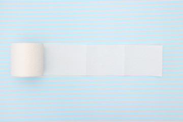 Unrolled toilet paper on  blue  background 