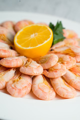 Large plate with boiled shrimps served with lemon