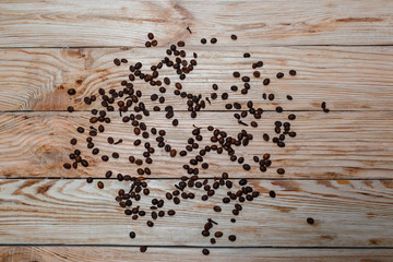 Scattered coffee beans and cloves on a light wooden table. Top view, place for text. Selective Focus