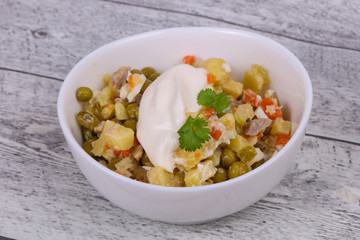 Traditional Russian salad with chicken in the white bowl