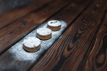 Three oatmeal cookies lie in a row. Homemade cakes are sprinkled with powdered sugar. Close-up, place for text. Shallow depth of field. Selective Focus