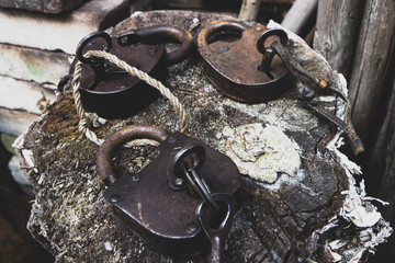 Old weathered grunge retro open and locked padlocks closeup on wooden background