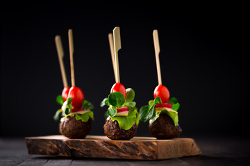 catering snack - minced meat balls with cherry tomatoes, lamb's lettuce and cheese