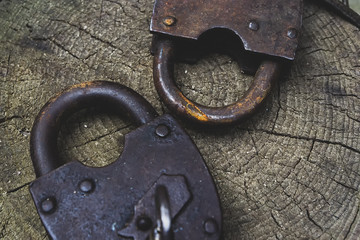 Old weathered grunge retro open and locked padlocks closeup on wooden background