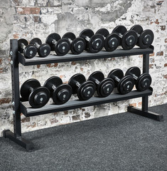 Fototapeta na wymiar Fitness Studio gym with storage for dumbbell set in front of a stone wall and adjustable Bench 