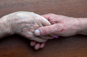 senior family couple holding old hands, psychological support concept