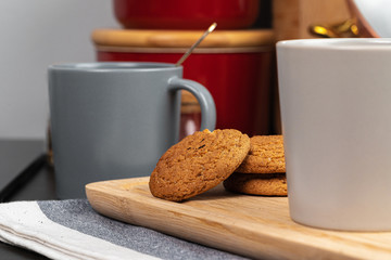 Cup of hot coffee on wooden board on kitchen table close up