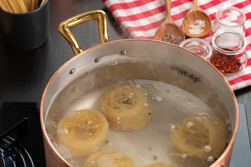 Cooking pasta at home kitchen  in a pot close up