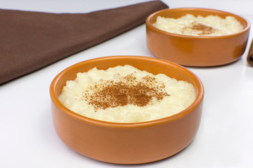 Traditional June party Brazilian dessert made of rice and condensed milk called arroz doce in white background