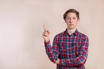 Fototapeta premium Young man pointing his finger up